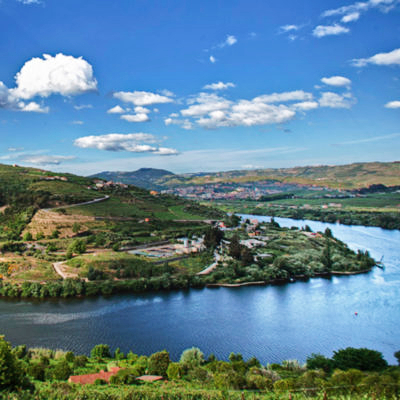 Image of the Douro River with mountains in the background and blue sky. Inside Douro - 3 days